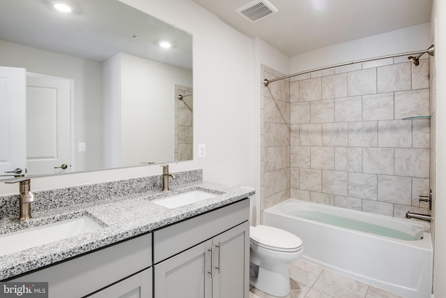 full bathroom featuring tile patterned flooring, vanity, toilet, and tiled shower / bath