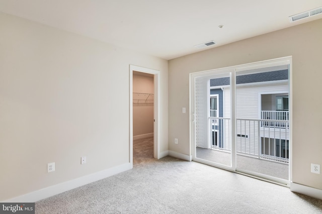 empty room featuring plenty of natural light and light colored carpet