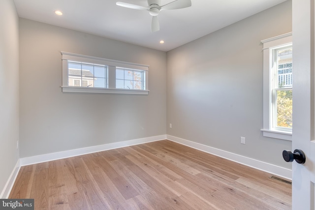 empty room featuring ceiling fan, a healthy amount of sunlight, and light hardwood / wood-style floors