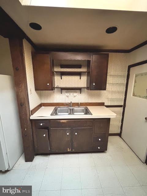 kitchen featuring white fridge, sink, and dark brown cabinetry