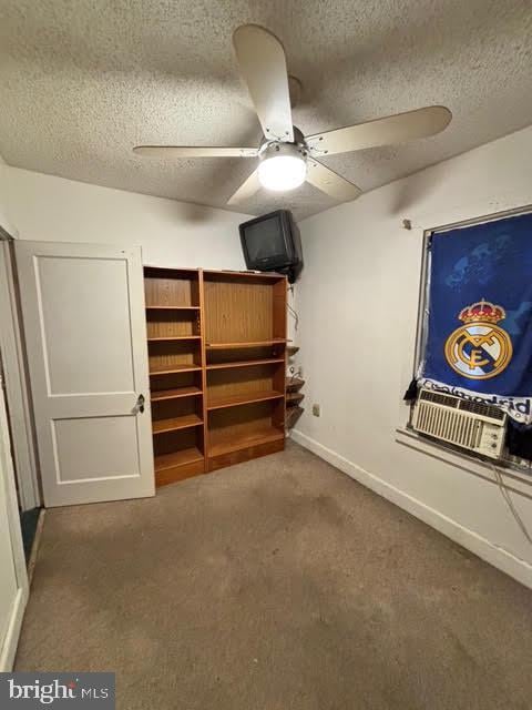 unfurnished bedroom featuring ceiling fan, carpet, and a textured ceiling