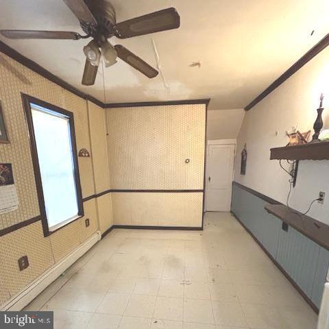 unfurnished room featuring ceiling fan and ornamental molding