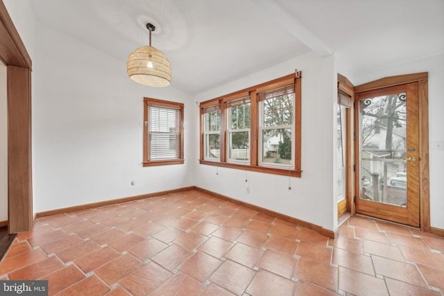 spare room featuring light tile patterned floors and vaulted ceiling