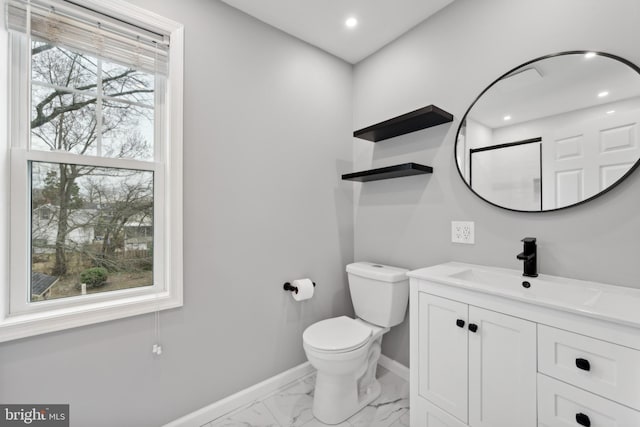 bathroom featuring a wealth of natural light, vanity, and toilet