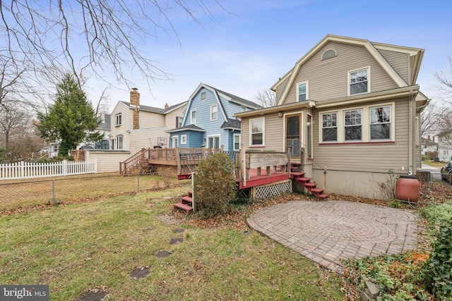 back of property with a wooden deck and a yard