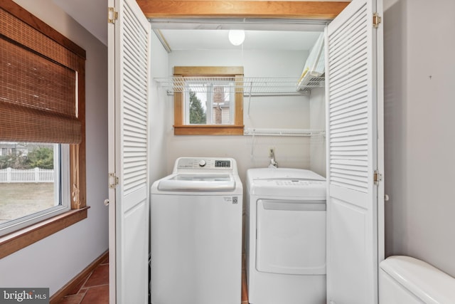 laundry room with washer and clothes dryer and tile patterned flooring