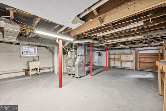 basement featuring heating unit and sink