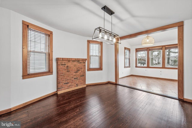 unfurnished dining area featuring vaulted ceiling with beams and dark hardwood / wood-style flooring