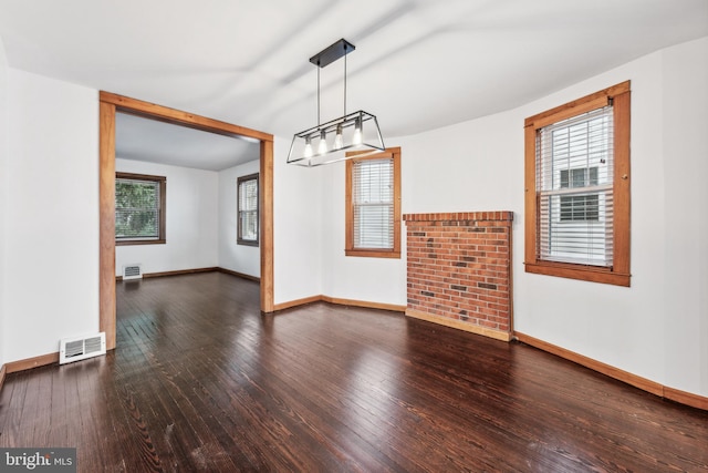 unfurnished dining area with dark wood-type flooring