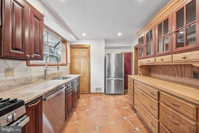 kitchen with sink, stainless steel appliances, tasteful backsplash, butcher block countertops, and light tile patterned floors