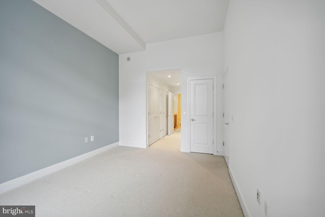 unfurnished room featuring light carpet