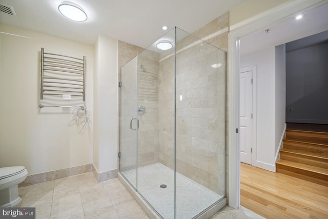 bathroom featuring tile patterned floors, toilet, radiator heating unit, and walk in shower