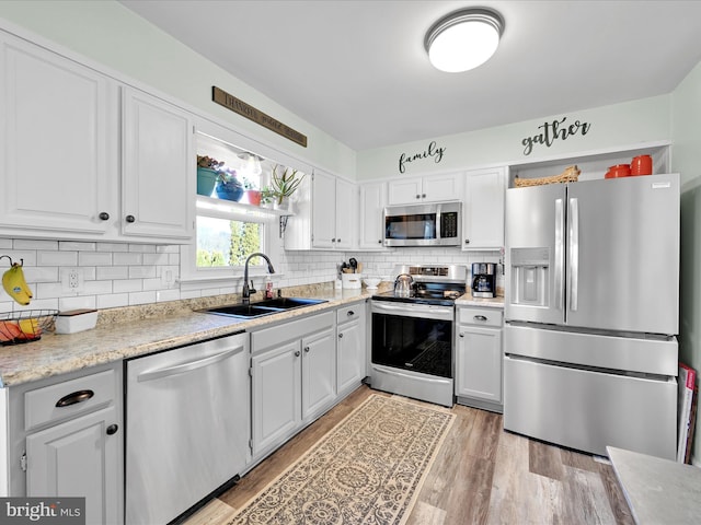 kitchen with sink, white cabinets, and appliances with stainless steel finishes