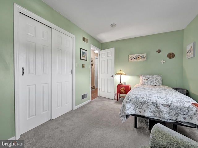 bedroom featuring light colored carpet and a closet