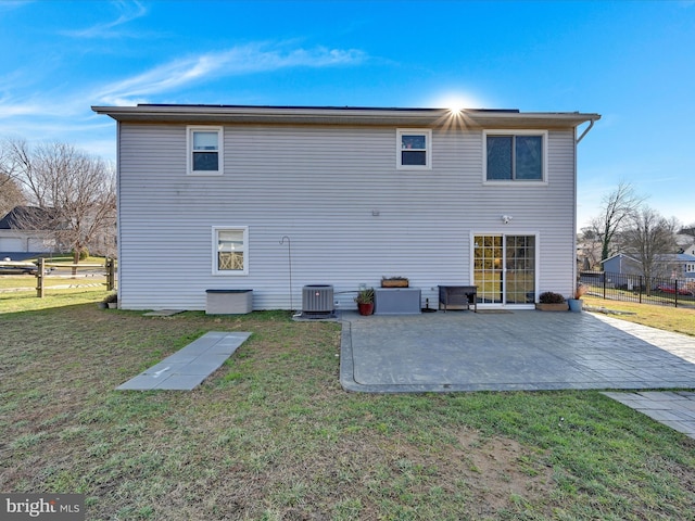 back of property with a patio area, a yard, and central AC