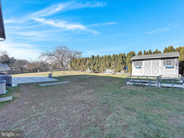 view of yard featuring cooling unit and a storage shed