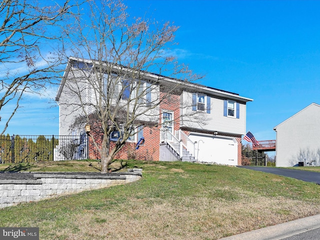 raised ranch with a garage and a front lawn