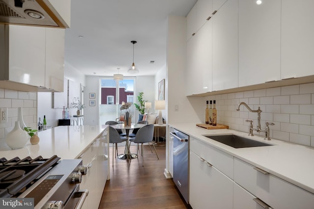 kitchen featuring decorative light fixtures, white cabinetry, sink, and tasteful backsplash