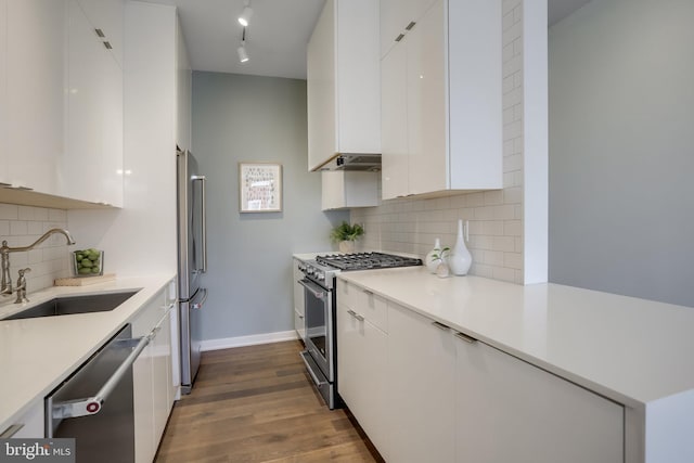 kitchen with sink, decorative backsplash, dark hardwood / wood-style flooring, white cabinetry, and stainless steel appliances