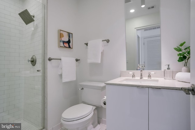 bathroom with vanity, toilet, and tiled shower