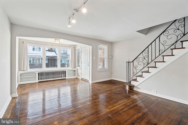 entryway with dark hardwood / wood-style flooring and radiator heating unit