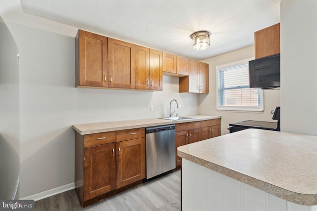 kitchen with stainless steel dishwasher, light wood-type flooring, range, and sink