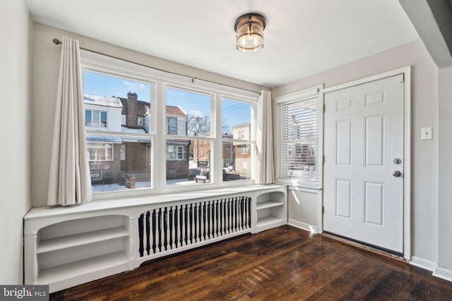 entrance foyer with dark hardwood / wood-style flooring and radiator heating unit