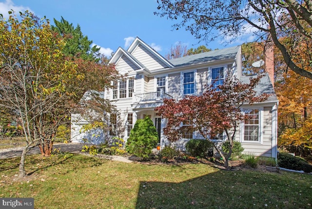 view of front of property featuring a balcony and a front yard