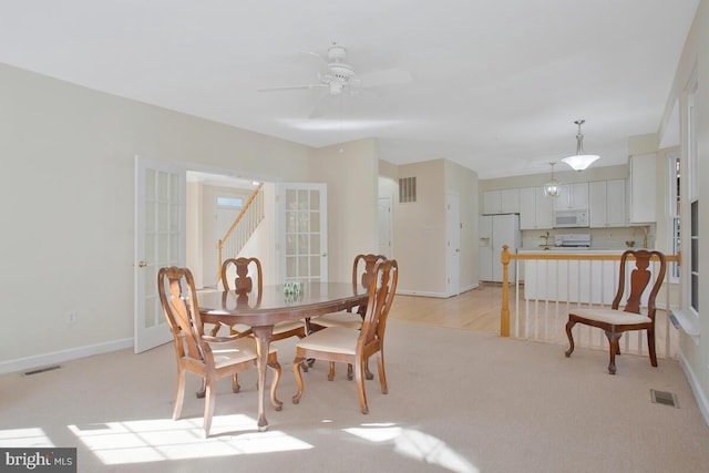 dining area with ceiling fan, sink, and light colored carpet