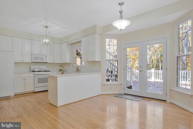 kitchen featuring white cabinets, pendant lighting, white appliances, and french doors