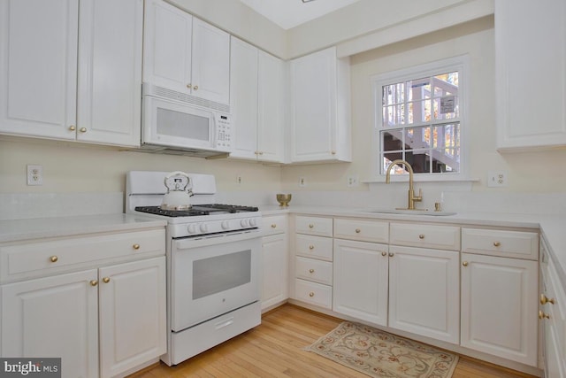 kitchen featuring white cabinets, white appliances, light hardwood / wood-style floors, and sink