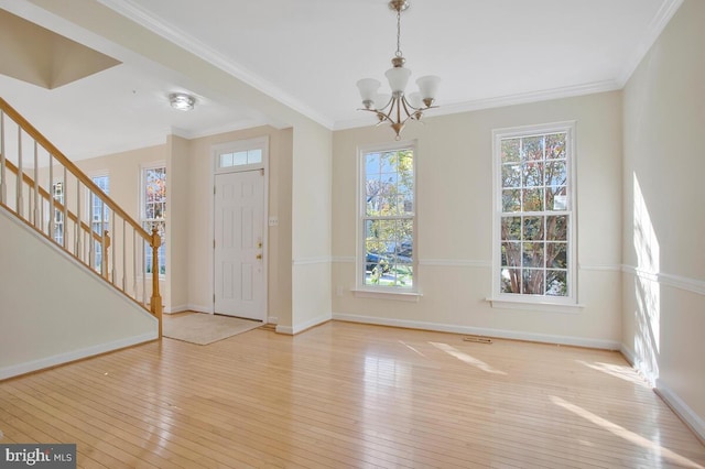 entryway featuring ornamental molding, light hardwood / wood-style floors, and a notable chandelier