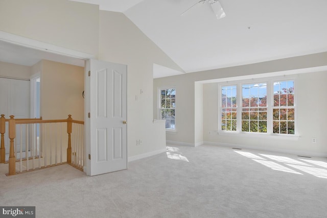 carpeted empty room featuring high vaulted ceiling