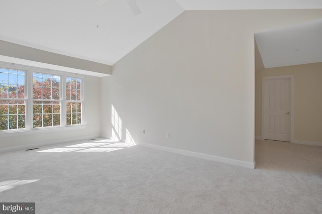 carpeted spare room featuring vaulted ceiling