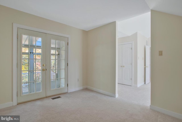 empty room featuring light colored carpet and french doors