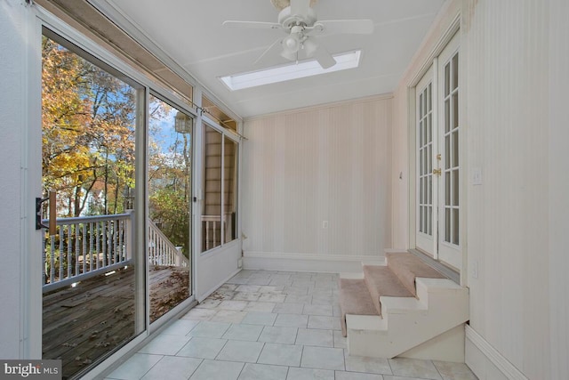 unfurnished sunroom with ceiling fan and a skylight