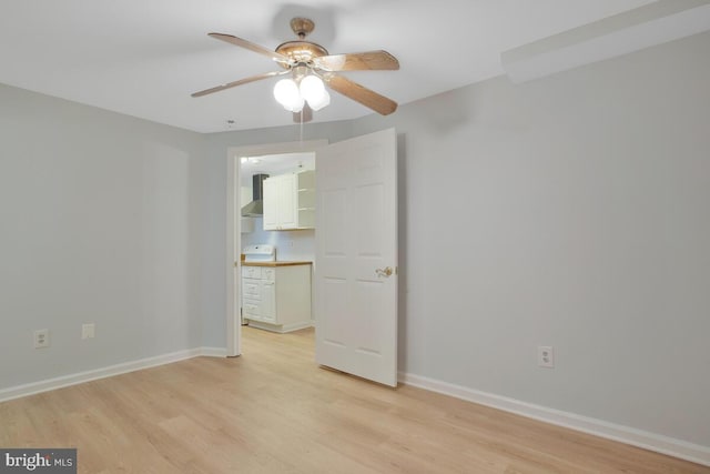 empty room with ceiling fan and light wood-type flooring