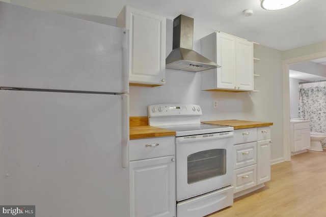 kitchen featuring white cabinetry, white appliances, wall chimney range hood, and wood counters