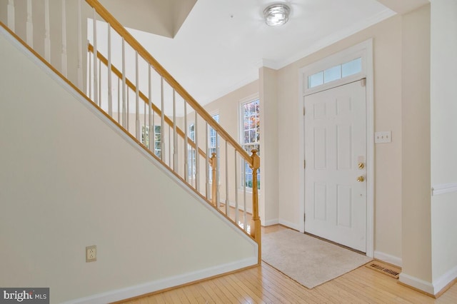 entrance foyer featuring light wood-type flooring and ornamental molding