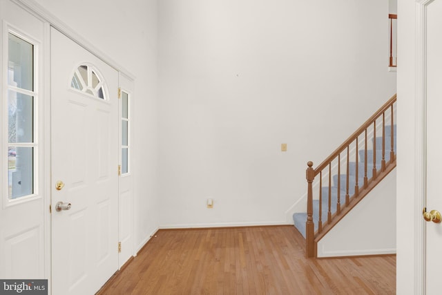 foyer entrance featuring stairway, wood finished floors, and baseboards