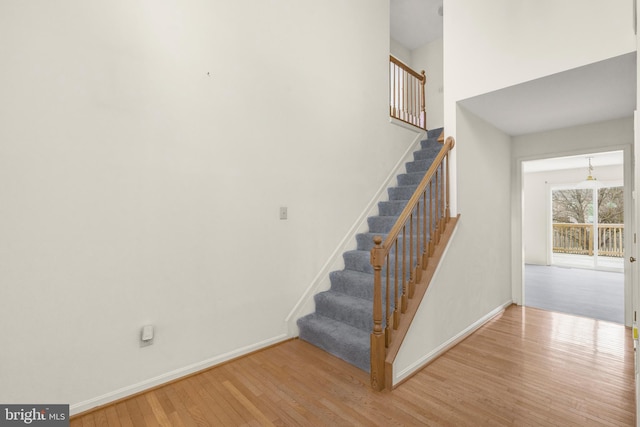 staircase with wood finished floors and baseboards