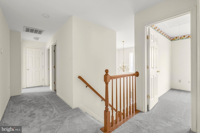 corridor featuring attic access, carpet, visible vents, and an upstairs landing