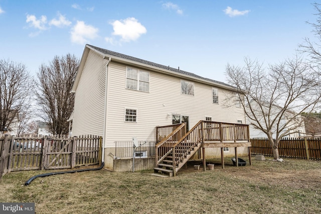 back of house with a fenced backyard, a lawn, a deck, and stairs