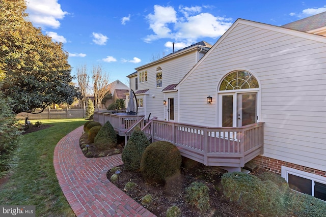 back of property with a deck and a yard