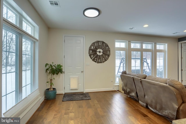 foyer entrance with wood finished floors, visible vents, and baseboards