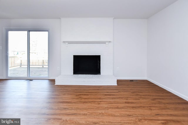 unfurnished living room with a fireplace and hardwood / wood-style floors