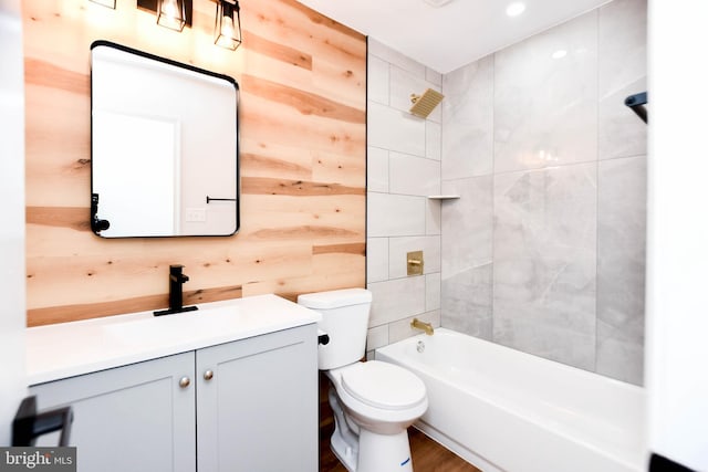 full bathroom featuring shower / tub combination, wood walls, vanity, and toilet