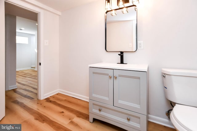 bathroom with hardwood / wood-style floors, vanity, and toilet