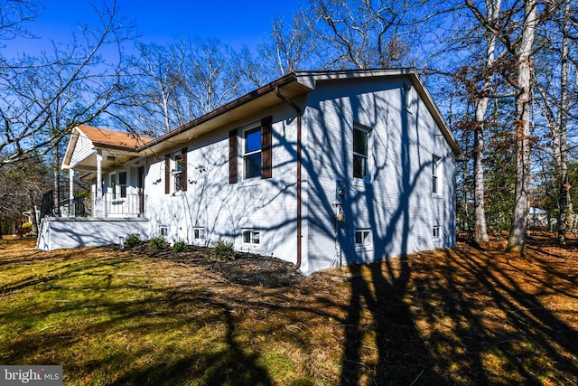 view of side of home featuring covered porch