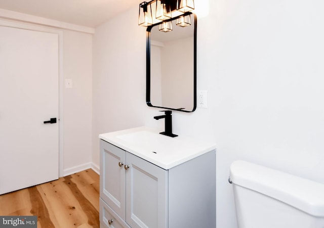 bathroom with hardwood / wood-style floors, vanity, and toilet